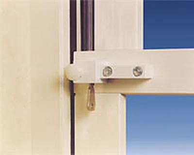 Bolt-style security lock fitted to a cream-painted timber window frame